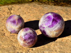 Three big amethyst spheres 70mm - 95mm on rock background