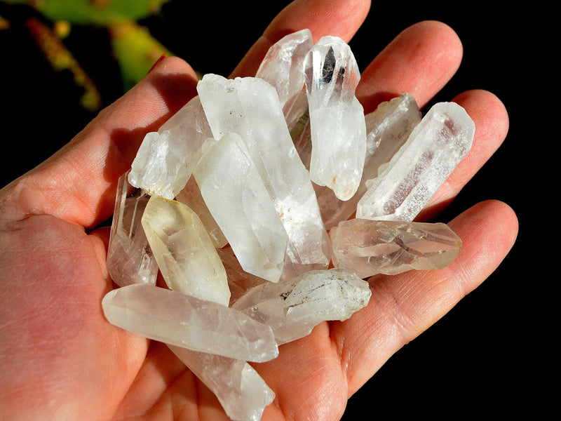 Several raw small crystal points on hand with black background