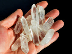 Some raw small crystal points on hand with black background