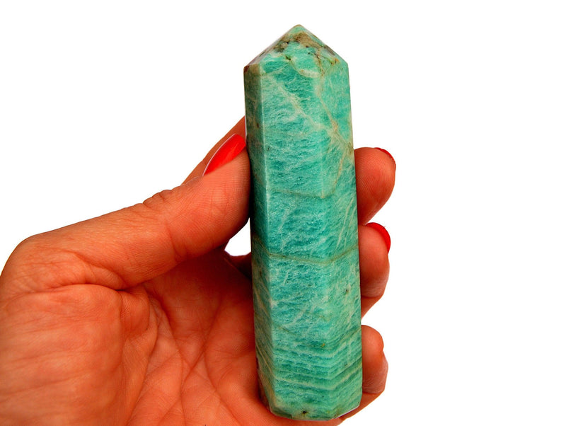 One amazonite crystal obelisk 95mm on hand with white background