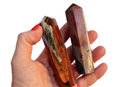 Two polychrome jasper crystal obelisks 90mm on hand with white background