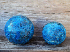 Large blue apatite crystal balls 70mm - 85mm on wood background