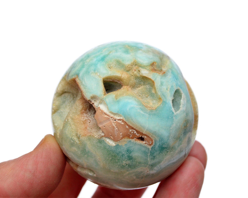 One druzy blue aragonite sphere crystal 55mm on hand with white background