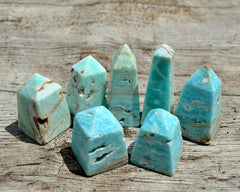 Some small blue green aragonite crystal obelisks on wood table