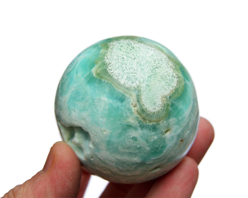 One blue green aragonite crystal ball 60mm on hand with white background