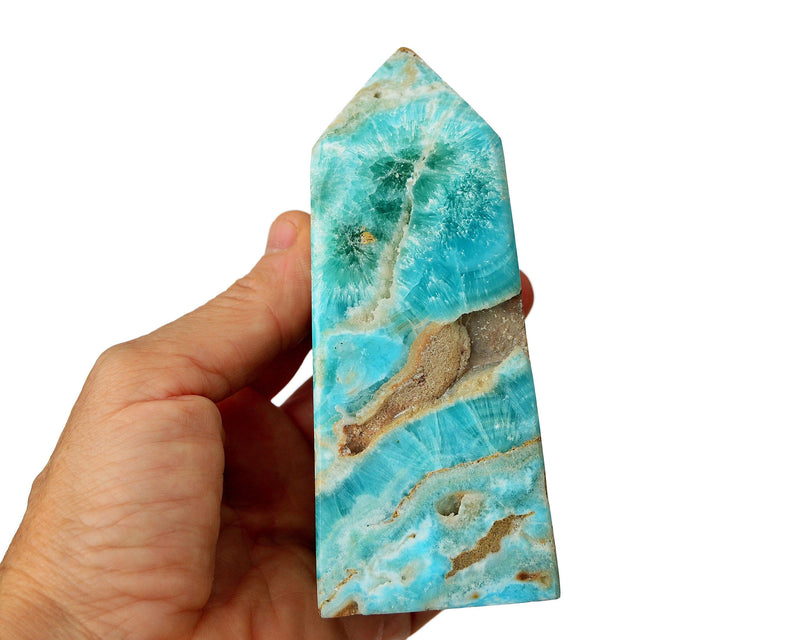 One large blue aragonite crystal tower on hand with white background