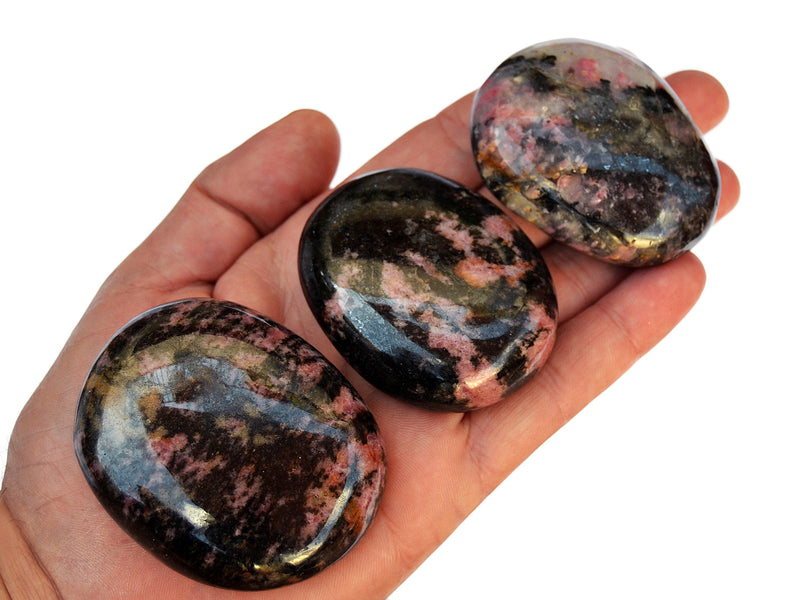 Three rhodonite palm stone crystals 70mm-40mm on hand